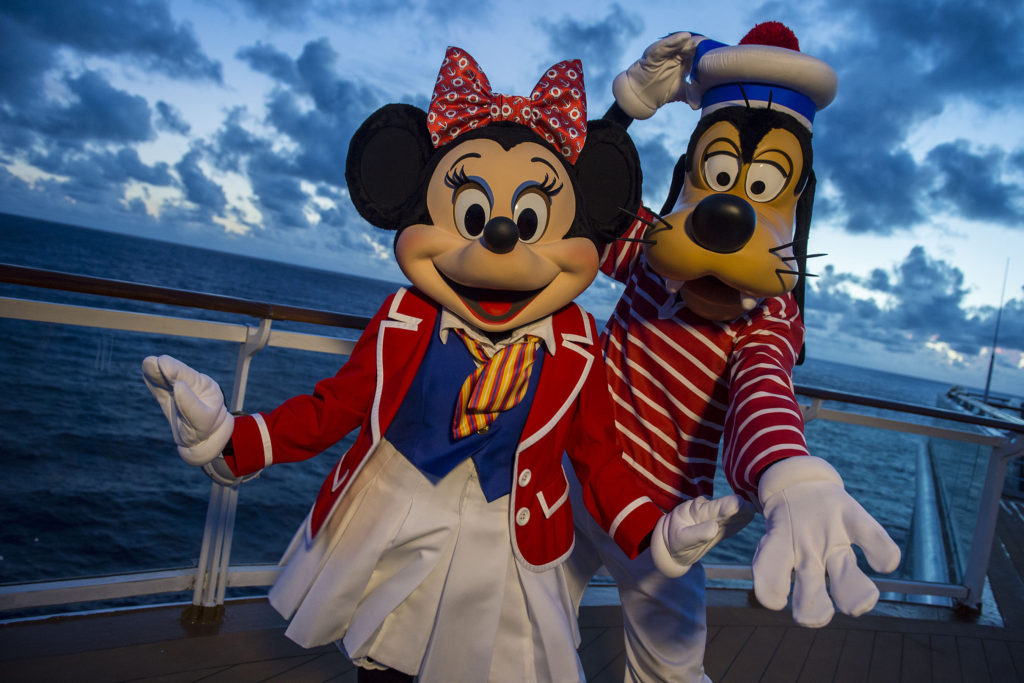 Minnie y Goofy saludan a los pasajeros en la cubierta del Disney Cruise Line durante la travesía. Minnie y Goofy saludan a los pasajeros en la cubierta del Disney Cruise Line durante la travesía.