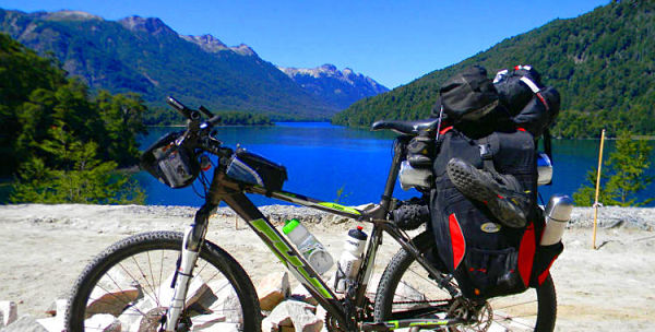 Bicicleta con mochila y bolsos estacionada frente a uno de los 7 Lagos en Argentina