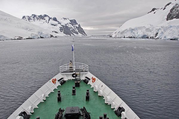 La forma más común de visitar la Antártida es a bordo de un barco de expedición, navegando por aguas gélidas entre glaciares e imponentes montañas nevadas.