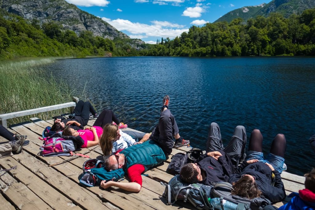 Personas descansando sobre un muelle junto a un lago en la Patagonia argentina