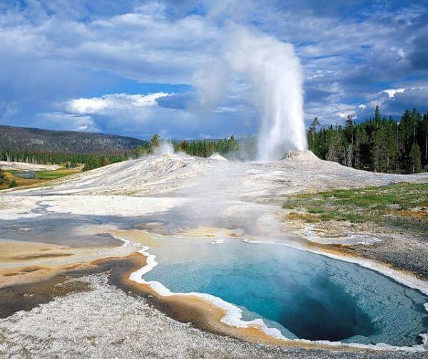 Géiser en erupción en zona geotérmica en Islandia Géiser en erupción en un campo geotérmico con aguas termales de color turquesa.