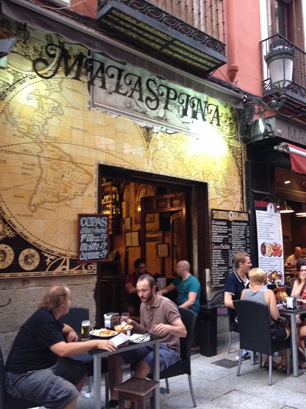 gente sentada bar malaspina, mesas en la vereda, pizarrones con elmenú