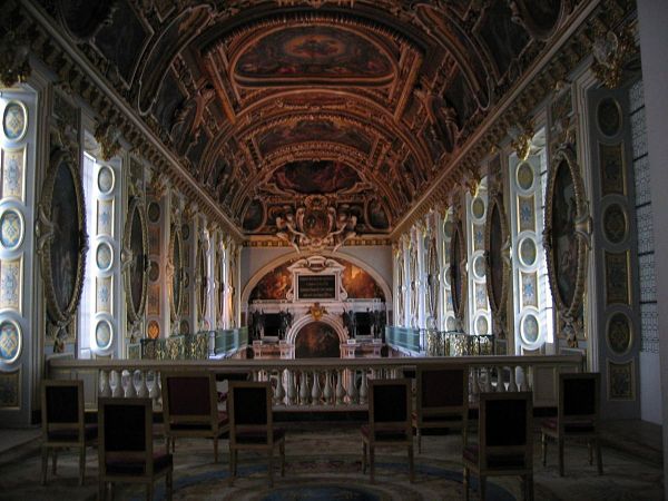 Interior del Palacio de Fontainebleau, Francia. Interior del Palacio de Fontainebleau, con una sala majestuosa decorada con frescos, lámparas de cristal y detalles dorados típicos del estilo renacentista francés.