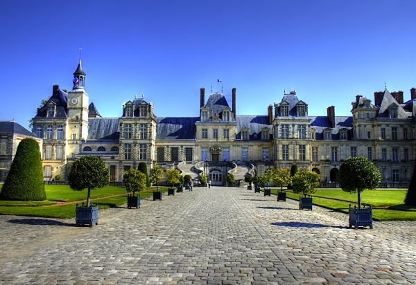 Palacio de Fontainebleau, Francia: arquitectura renacentista y jardines reales Fachada principal del Palacio de Fontainebleau con jardines y cielo despejado