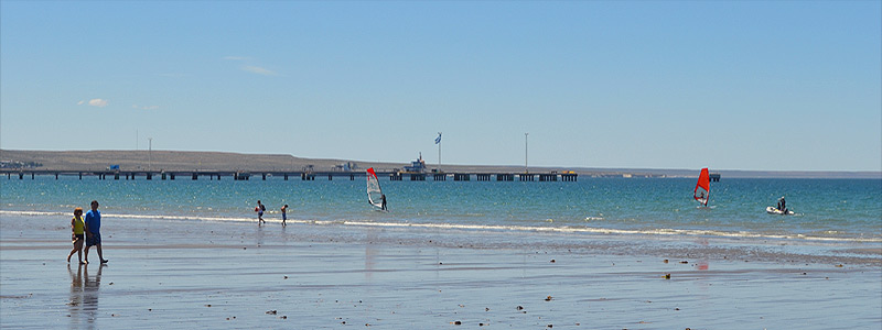 Playa céntrica de Puerto Madryn con sombrillas y vista al mar. playas de puerto madryn