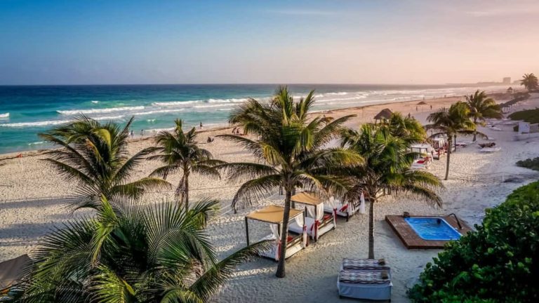 Olas, arena, palmeras y mesas para tomar algo. Hermosas playas de Canc&uacute;n para el verano
