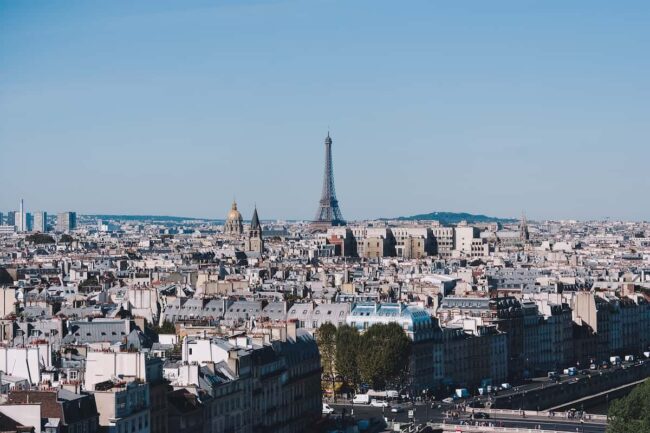 Vista panorámica de París con la Torre Eiffel al fondo en un día despejado.