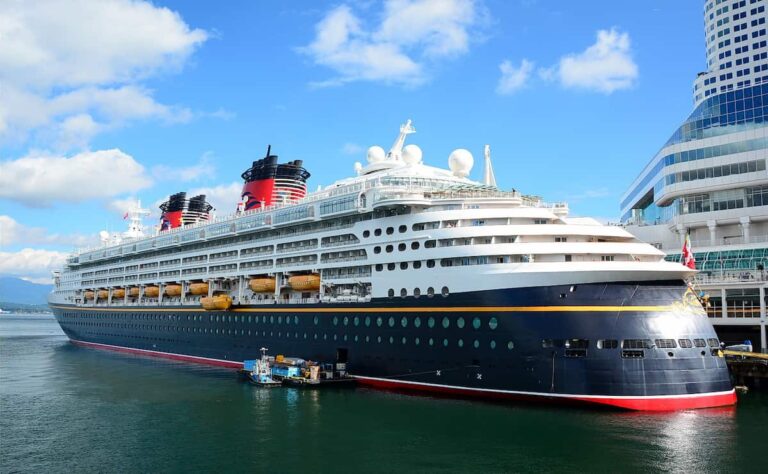 Crucero de Disney atracado en el puerto con sus caracter&iacute;sticas chimeneas rojas y negras.